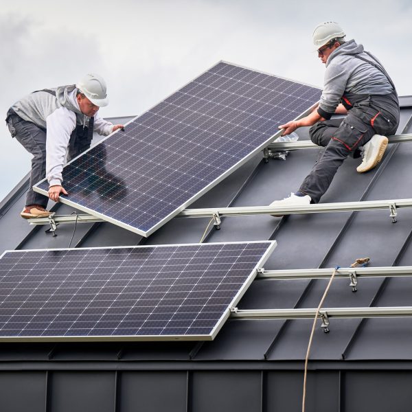 Workers building solar panel system